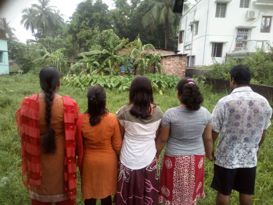 Malina & her family standing in front of the land